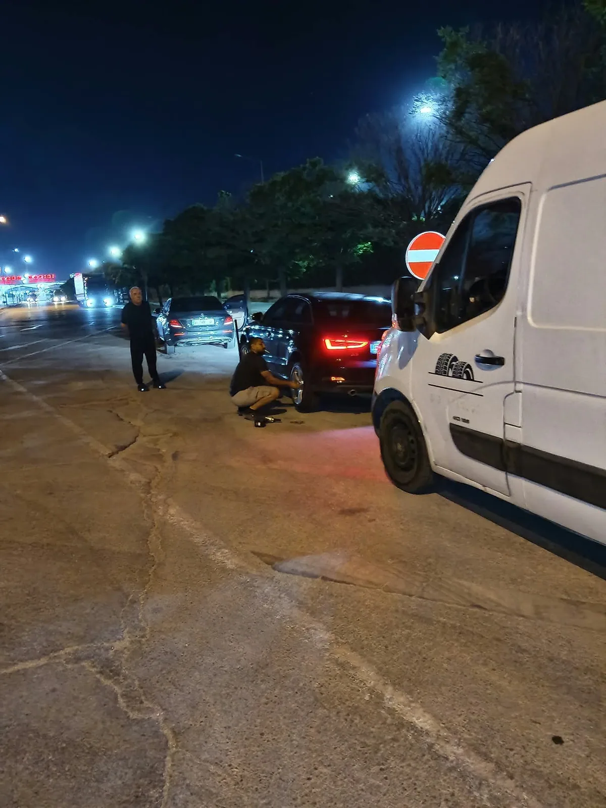 Gece tesis girişinde binek aracın tekerleği değiştiriliyor